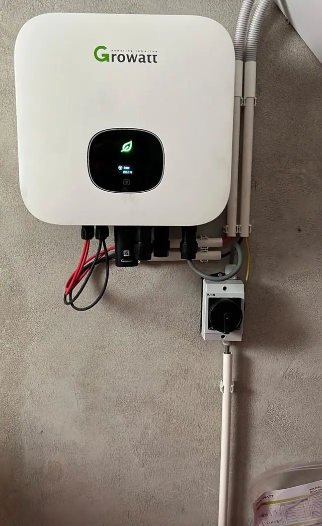 Omvormer aan de muur in de bijkeuken, met de aansluitkast eronder