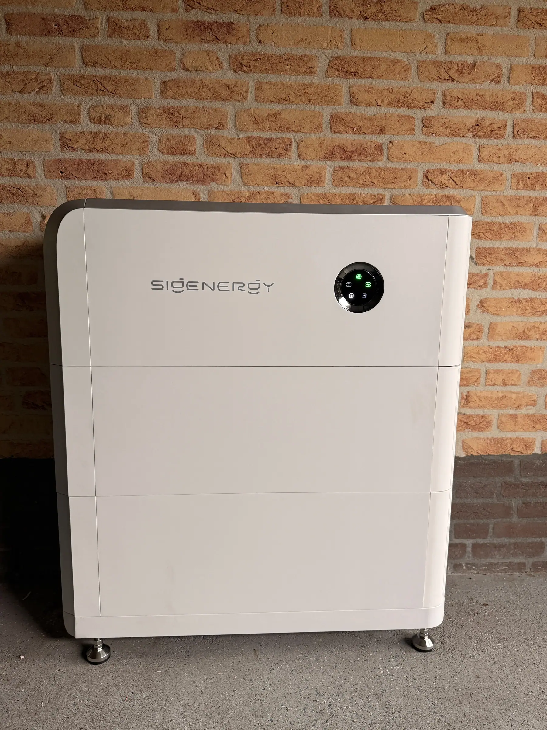 Thuisbatterij tegen een bakstenen muur in de garage