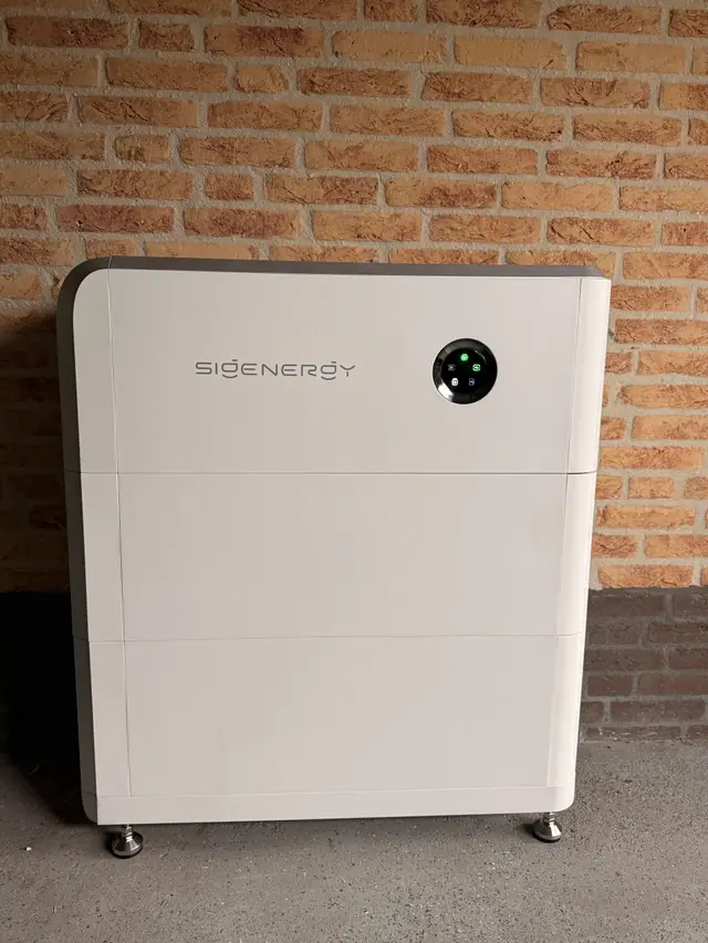 Thuisbatterij tegen een bakstenen muur in de garage